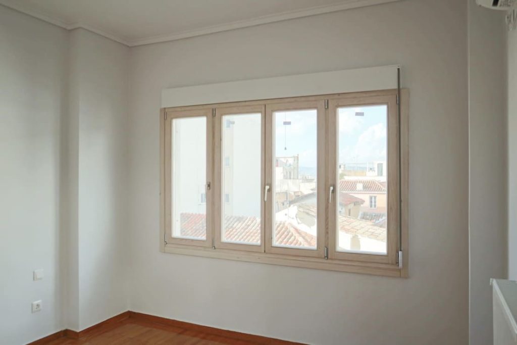 Δωμάτιο διαμερίσματος με τετράφυλλο ξύλινο παράθυρο με θέα