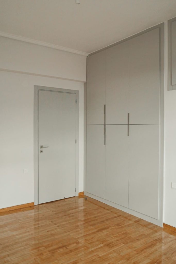Δωμάτιο διαμερίσματος με εσωτερική ξύλινη πόρτα γκρί και ντουλάπα γκρί
